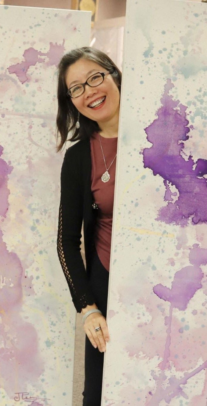 Joanna Purvis, founder of PEPS Arts, beside one of her watercolor canvases