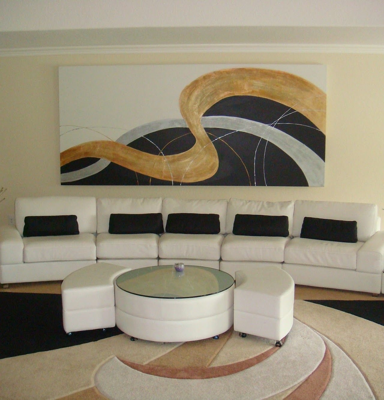 Gold ribbon painting by Joanna Purvis above a white sectional