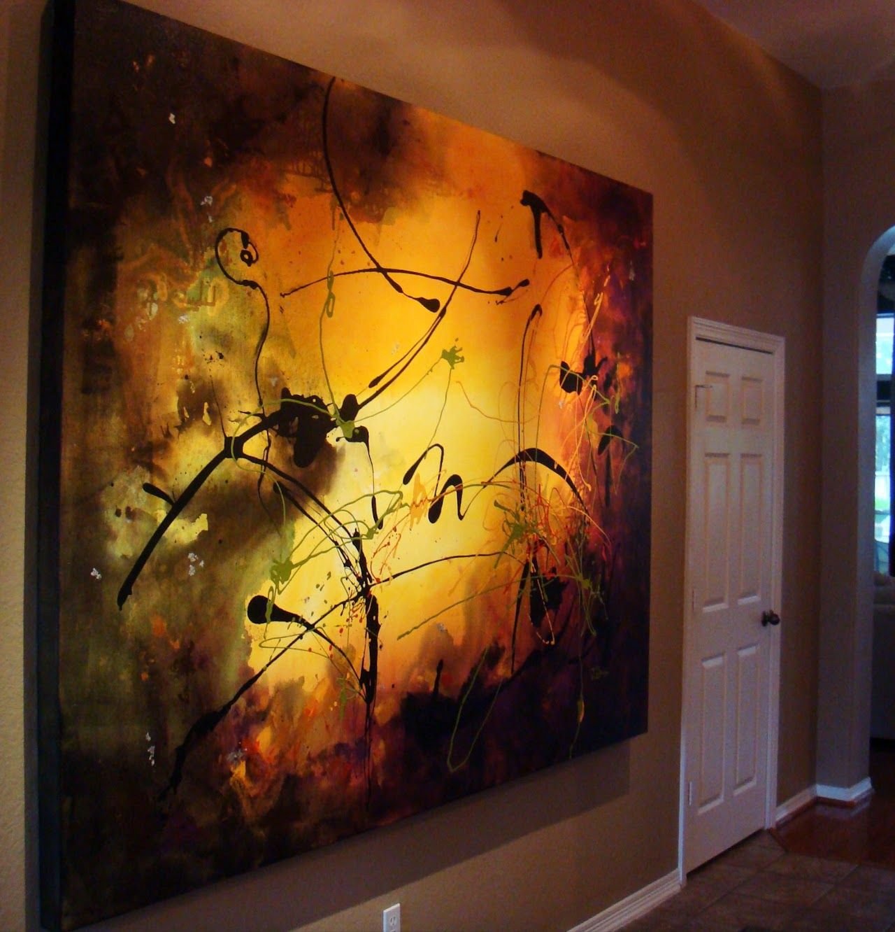 Amber and black abstract painting by Joanna Purvis in a hallway