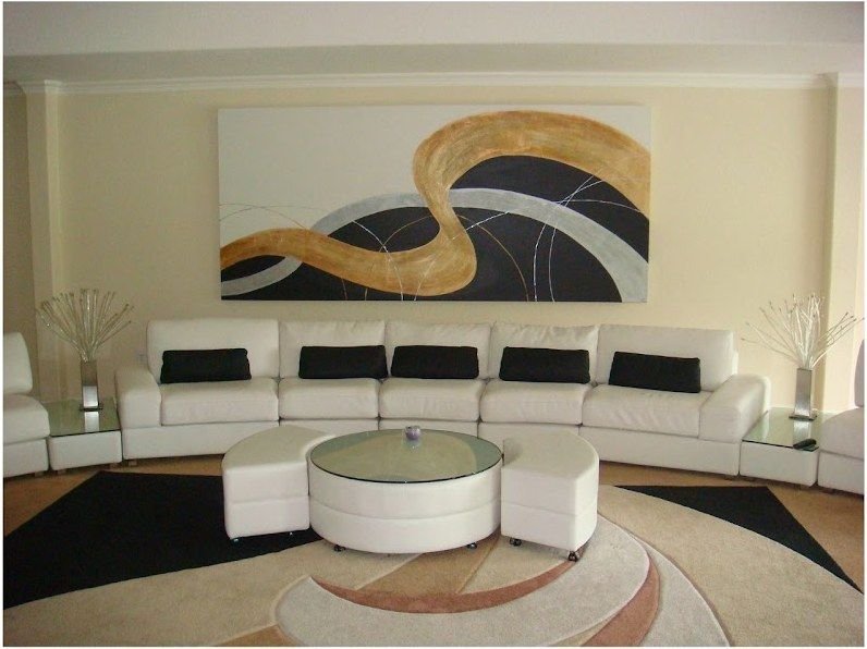 Long gold and black abstract painting by Joanna Purvis above a white sectional